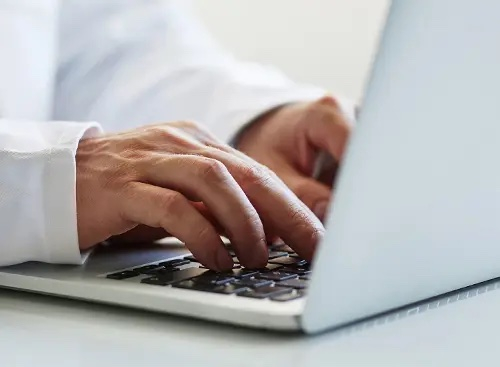 hands typing on a laptop